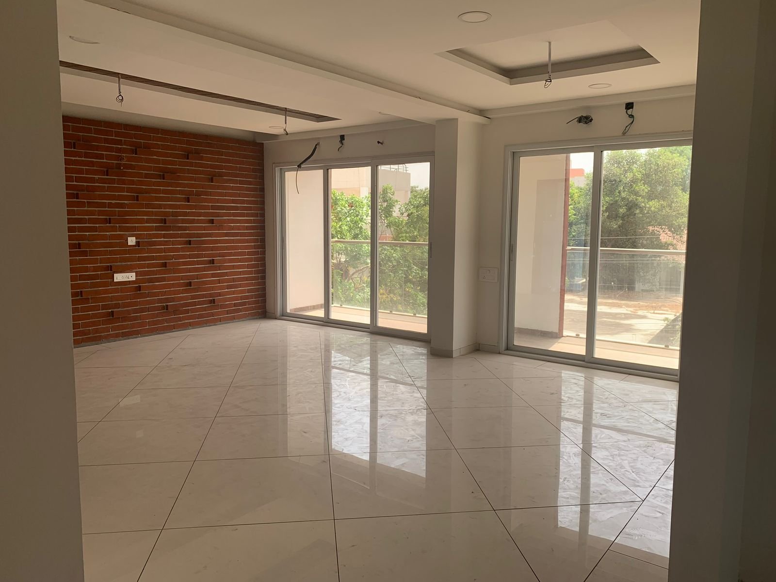 Bare shell living area with exposed brick wall before renovation